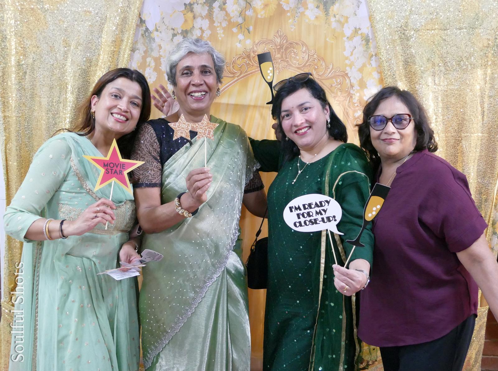 Guests posing with movie star photo booth props at a Sydney Queens event